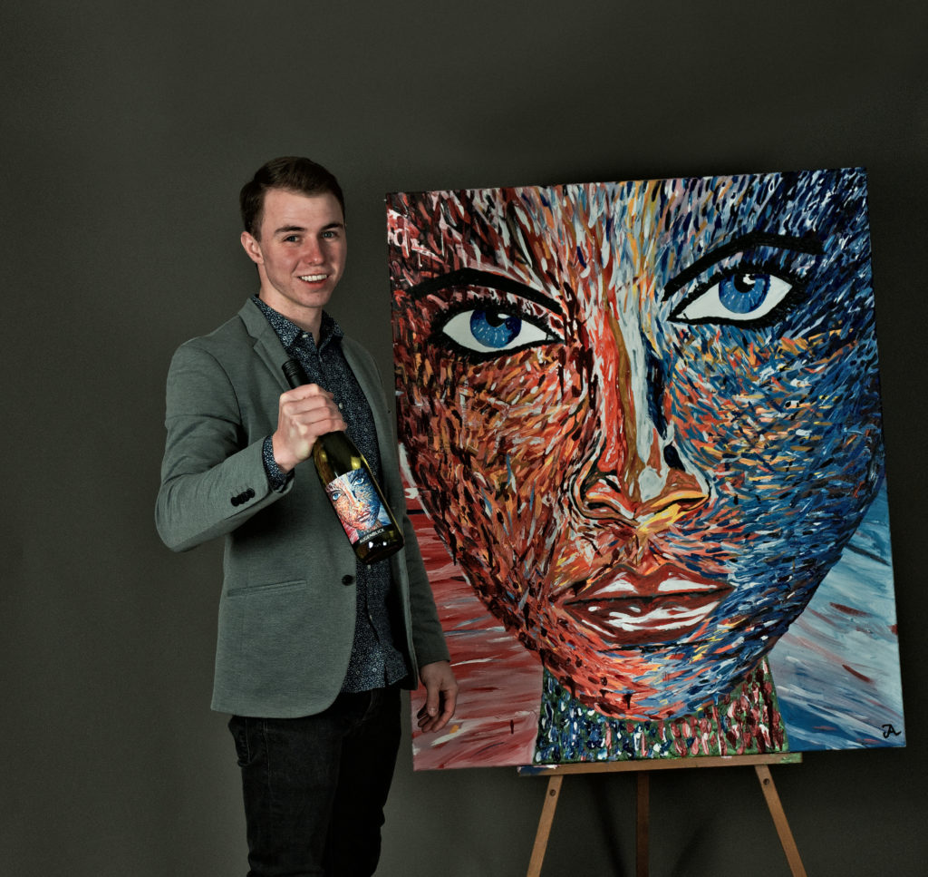 Jakob Lang steht vor Augenblick Bild mit Flasche Wein in der Hand